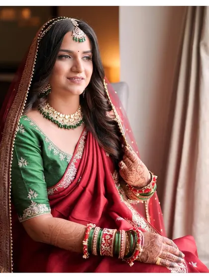 A contemporary bride in a stunning red saree-style lehenga. Samruddhi's look is a beautiful blend of modern styling and traditional colors, with a natural, glowing complexion.