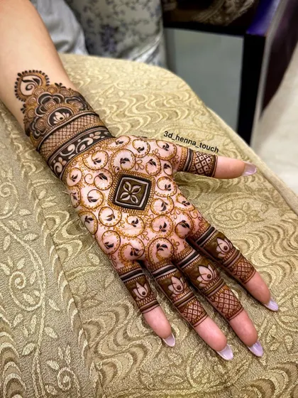 A close-up of a hand with a unique swirling pattern. The central geometric element is surrounded by delicate, airy circles, creating a modern and stylish look.