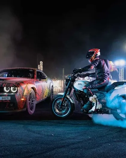 We bring the full cinematic experience to your event. Here, one of our riders performs a precision burnout alongside a custom Dodge Challenger, enveloped in dramatic smoke and lighting for an unforgettable night show.