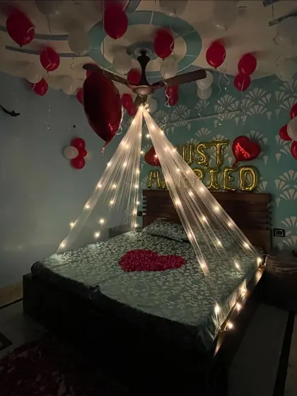 This angle captures the romantic ambiance created by the fairy light canopy and the floating balloons in the 'Just Married' room setup.