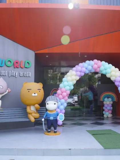 A beautiful pastel rainbow balloon arch welcomes guests to a special birthday celebration at our main entrance.