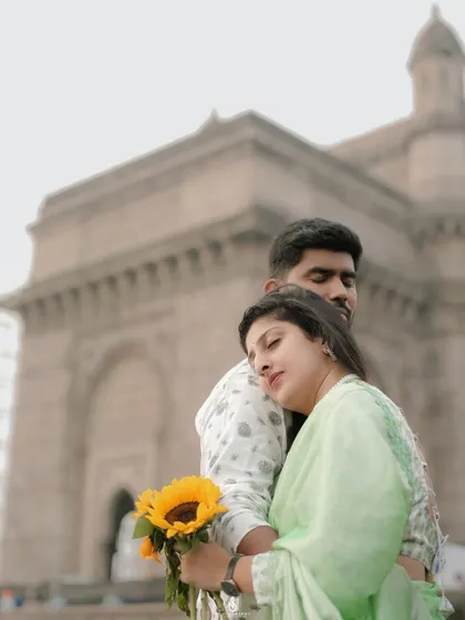 A peaceful and affectionate pose, with her resting on his shoulder, looking out at the view.
