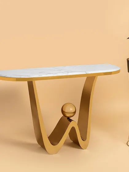 This console table features a playful, modern wave design in its stainless steel base, complete with a balancing sphere accent. The sleek marble top provides a clean surface, making it an eye-catching piece for a hallway or living room.