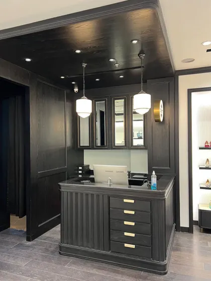 A detailed shot of the cash and wrap counter, showing the craftsmanship of the custom millwork and the integration of storage and transaction equipment.