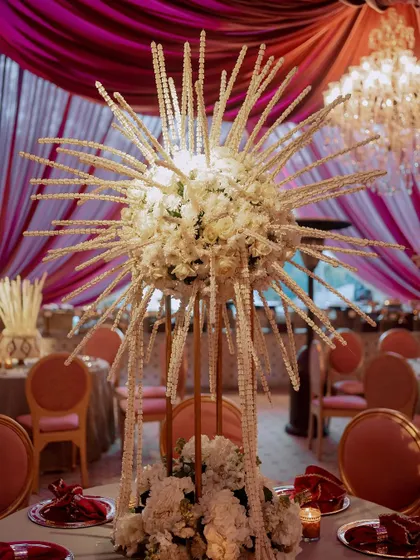 A unique, starburst-style centerpiece made from hundreds of tuberose strings. This sculptural floral piece adds a modern twist to a traditional wedding flower.