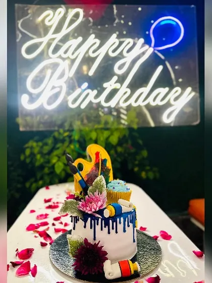 Unleash your inner artist with this creative, art-themed cake. It's adorned with an edible painter's palette, brushes, and tubes of paint, all set against a vibrant blue drip effect.