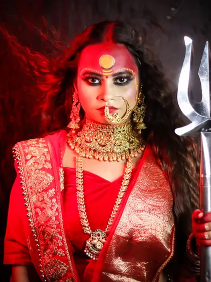 A powerful portrait of a student as a goddess, holding a trishul and exuding strength.