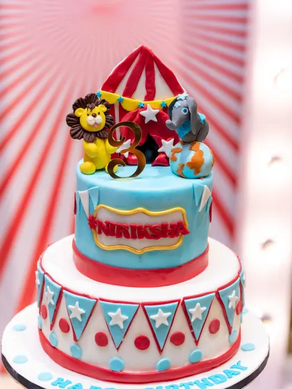 A vibrant circus-themed cake for a third birthday party. The bright colors and fun details of your cake will pop in our photos.