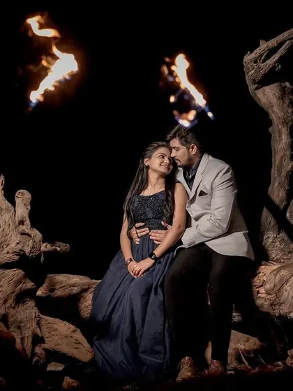 A wide shot of the couple sitting together at night, surrounded by fire. This creates a very dramatic and powerful pre-wedding scene.
