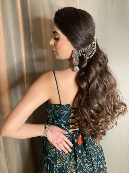 The back profile of this desi look, showing off the beautiful wavy ponytail with a silver hair accessory. It's a great hairstyle for keeping hair managed while still looking festive.
