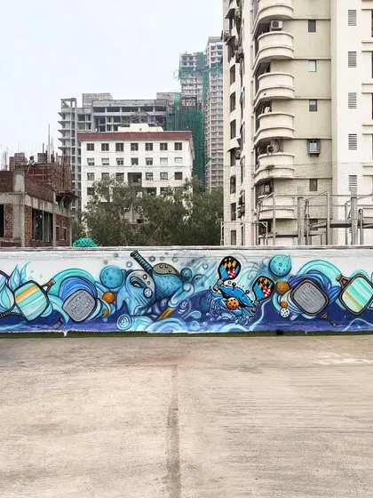 This is a massive graffiti mural I painted for a pickleball court. The entire wall is filled with dynamic, abstract shapes and characters related to the sport.