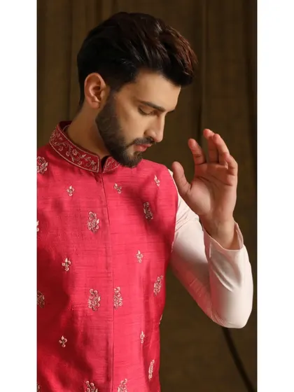 A detailed shot of the 'Gulab Dev' bandi set. The focus is on the radiant pink fabric of the jacket and the delicate floral embroidery, a perfect look for spring weddings or festive events.
