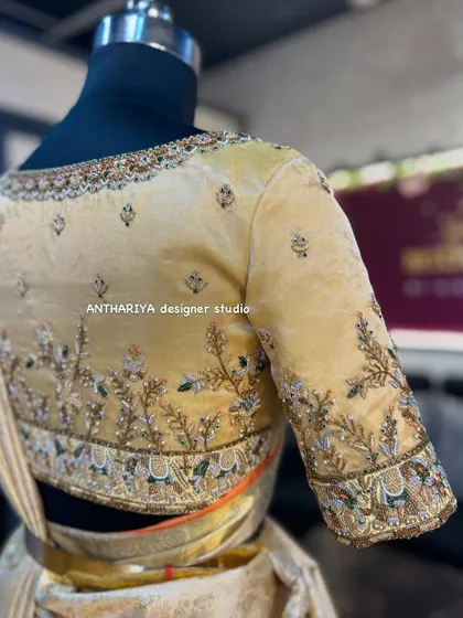 An elegant cream-colored bridal blouse with delicate floral and bird embroidery.