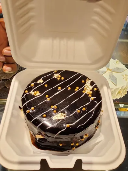 bento cake, perfect for a personal celebration or as a sweet gift. This mini cake is decorated with a rich chocolate glaze and gold sprinkles.