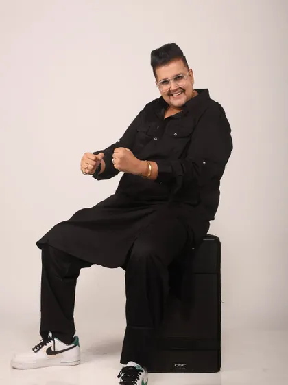 A playful moment during a photoshoot. Even when I'm sitting down, the energy is always on. Dressed in a stylish black kurta, I'm ready to get the party started.