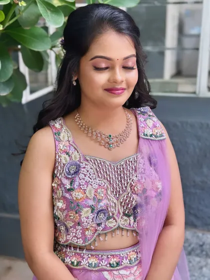 Charitha on her engagement day. This look features a soft, dewy base and pink-toned makeup to complement her intricately embroidered lavender lehenga.