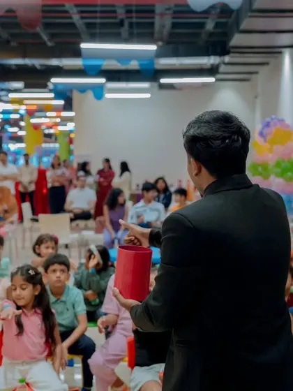 A view from behind me as I perform for a full house at a kids' play zone. The audience includes both children and their parents, as my show is designed for the whole family to enjoy together.