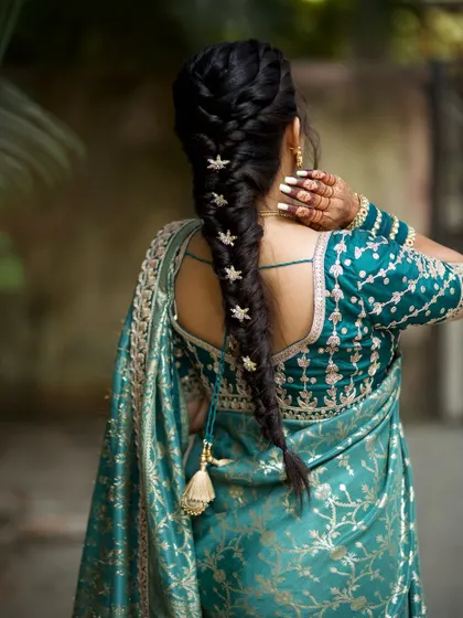 A beautiful shot of the bride's hairstyle and the hint of her mehendi on her hand.