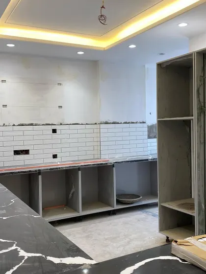 Another angle of the work-in-progress site. You can see the cabinet carcasses and the tall unit frame being set up, showing how the kitchen layout starts to take shape.