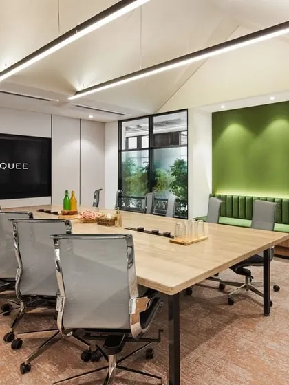 The main conference room at CorporatEdge, Bangalore, designed with a pitched ceiling and integrated greenery. This space combines formal meeting requirements with biophilic elements to create a refreshing and inspiring atmosphere for collaboration.