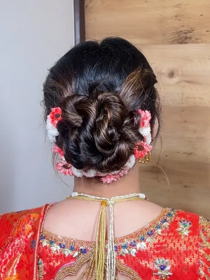 A beautifully woven floral bun using a mix of fresh flowers. This style adds a touch of natural elegance and is perfect for a daytime wedding or traditional ceremony.