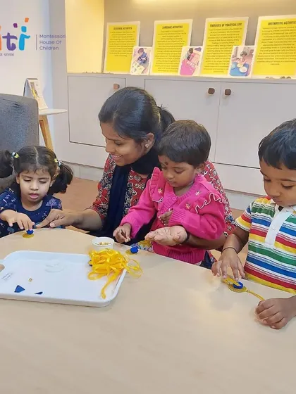 A teacher helps our youngest children with a Rakhi-making craft. This simple, tactile activity allows toddlers to participate in the festival of Raksha Bandhan.