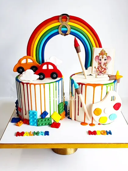 A special cake for twins with different interests. One side is for the car and Lego lover, the other for the little artist, all united by a beautiful rainbow. A true custom creation!