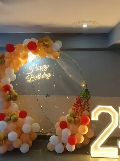 A duplicate of the peach, white, and red semi-circular balloon arch setup for a 25th birthday.