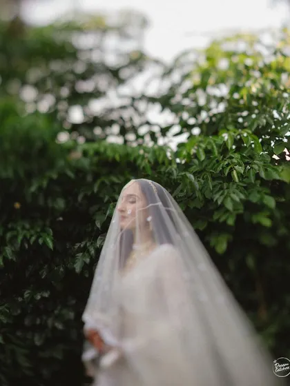 A soft, dreamy portrait of the bride with her eyes closed, her face partially covered by her veil.