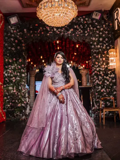 A stunning bride ready for her engagement or reception party in a lavender gown with a dramatic cape. A full-length shot showcasing her complete, glamorous look.