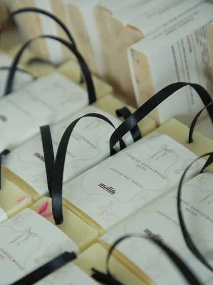 A collection of scented wax tablets with black ribbons, designed as elegant favors for a baby shower.