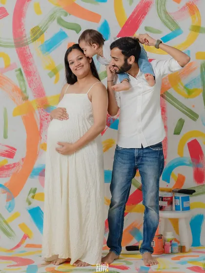 A family portrait against a hand-painted colorful backdrop, a bespoke theme celebrating the new life to come.