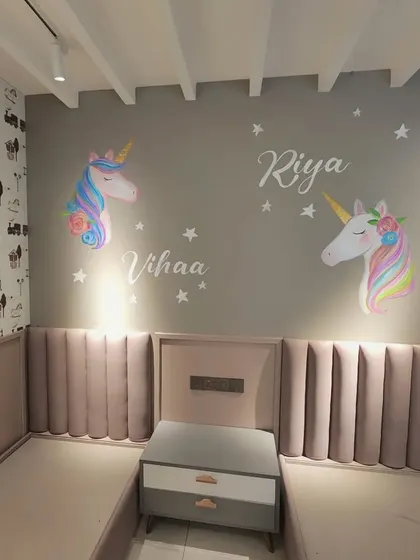 A wider view of the unicorn wall, showing how the artwork is placed above the beds to create a dreamlike atmosphere.