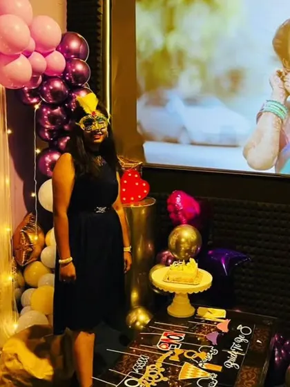 The complete setup for a bride-to-be celebration, with a personalized photo on the screen, a decorated cake table, and plenty of fun props for the guests.