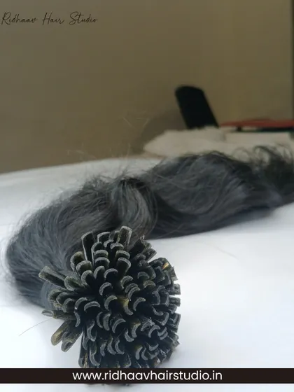 A close-up of our U-Tip Wavy Hair Extensions. The U-shaped keratin tip is designed to be melted and fused to the natural hair for a strong, long-lasting bond that blends seamlessly.