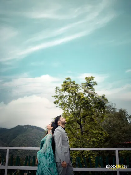 A creative shot of a couple standing back-to-back against a beautiful sky and mountain backdrop, symbolizing their individual strengths and shared future.