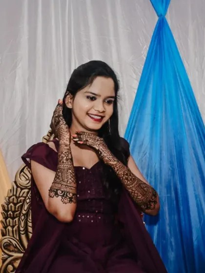 A happy client showing off her engagement mehendi after the color has fully developed. The dark stain looks beautiful in photos.