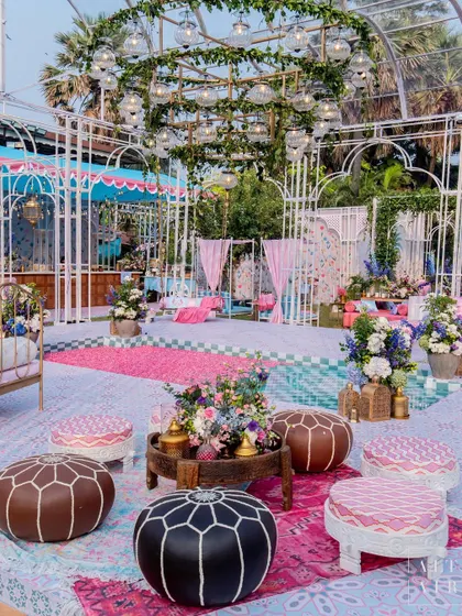 Another view of the 'Botanical Marrakesh' glasshouse, with Moroccan-style poufs and layered rugs creating a relaxed and immersive ambiance for the Mehendi ceremony.