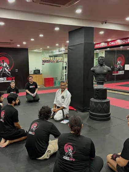 We don't just train together, we grow together. Students listen intently to a senior instructor, absorbing wisdom that goes beyond physical technique.