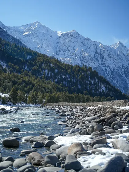 A collection of breathtaking landscapes from Spiti. These images feature the majestic snow-capped peaks, the turquoise river, and the dramatic, winding roads carved into the mountainside.