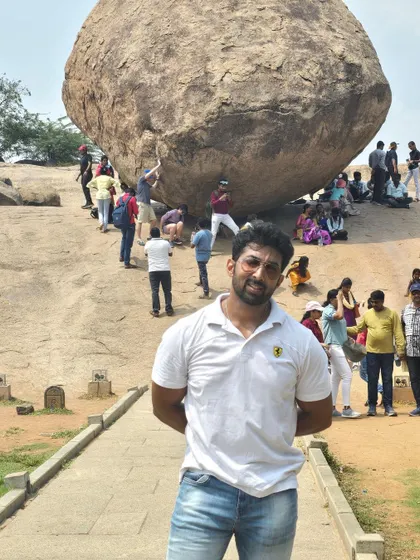 Standing in front of 'Krishna's Butterball', a giant balancing rock that has defied gravity for centuries.