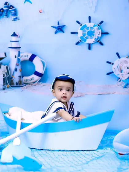 A full view of the sailor-themed setup, with the baby boy looking curiously at his surroundings.