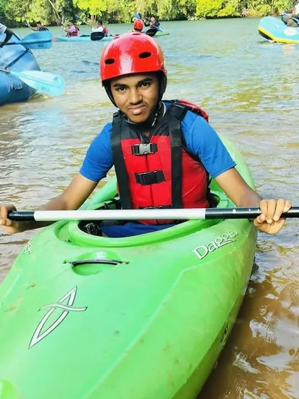 A close-up of a student in his kayak, fully equipped with a helmet and life jacket, ready to learn.