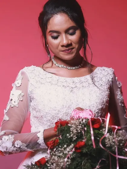 Another shot of the bride holding her bouquet. The soft makeup and elegant hairstyle are perfect for a Christian wedding.