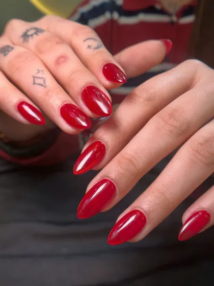 You can never go wrong with a classic red. This is a vibrant, glossy red gel polish on beautifully shaped almond nails. It's a powerful and confident look for any occasion.