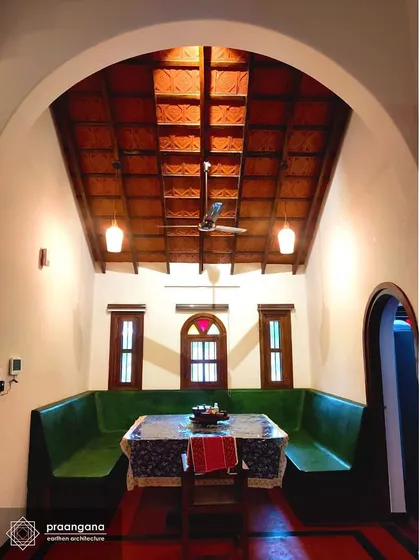 The dining area in the Udupi house, with its built-in green oxide seating and high vaulted ceiling. This space is a perfect example of how we integrate furniture and architecture to create unique, functional rooms.