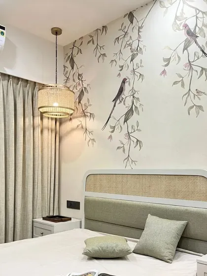 A wicker headboard and floral chinoiserie wallpaper come together in this beige retreat where nature meets elegance.
