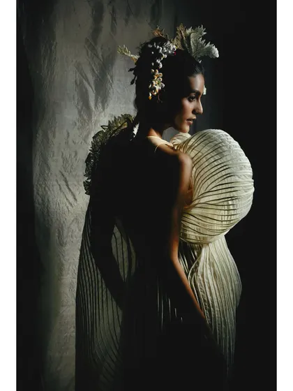 A profile shot emphasizing the silhouette of a Vaishali S couture piece. The dramatic side lighting creates a high-contrast image that feels both classic and modern.