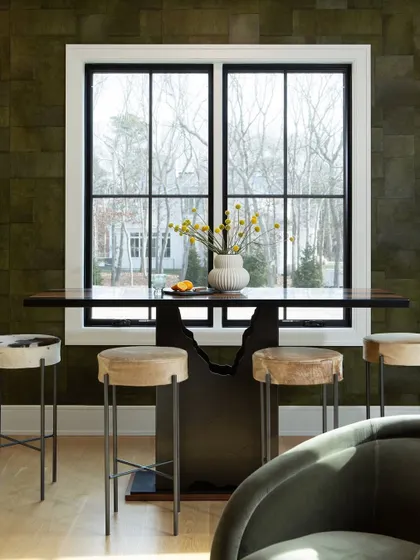 A stylish bar area set against our 'Appaloosa' wallpaper. The stools, upholstered in a mix of cowhide and neutral fabrics, demonstrate how different textures can be combined for a sophisticated and eclectic look.