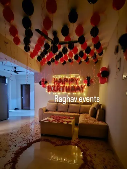 Another view of the romantic living room setup with red and black balloons. The rose petal heart on the floor adds a special touch.